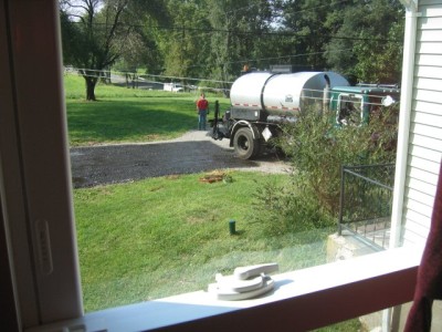 laying the tar & chip driveway.  read about it here.  and see how the tar and chip looks 2 years later, in the next photo.  It recently developed a large pothole after unusually heavy rains.  See photos on next few pages.