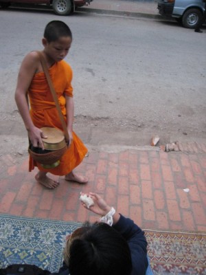Luang Prabang, young monk receiving food